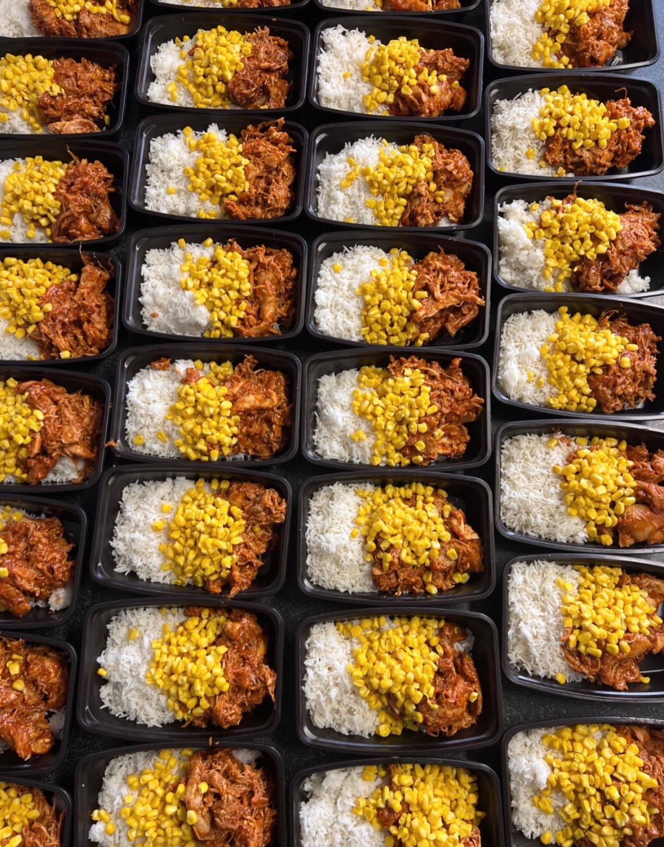 BBQ chicken bowls with basmati rice and sweet corn, portioned in trays