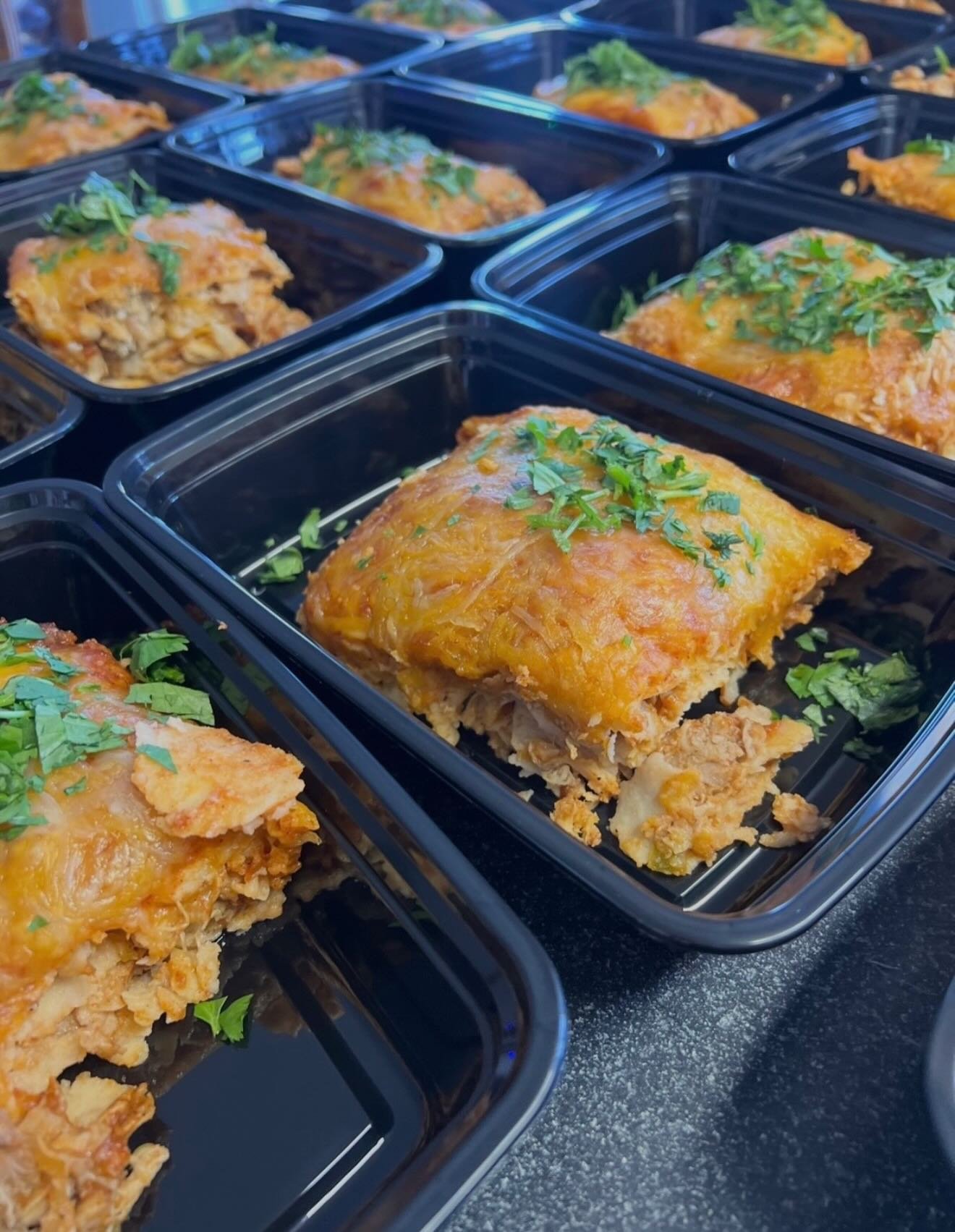 Cheese-topped red sauce chicken enchiladas garnished with cilantro